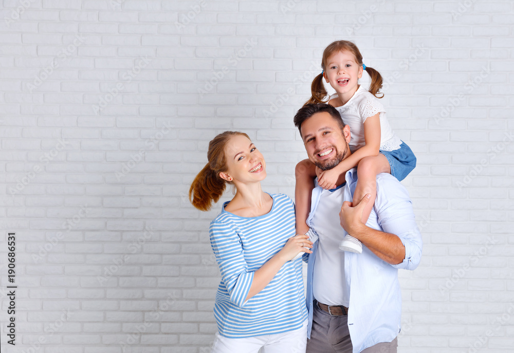 happy family mother father and child  near an empty brick wall