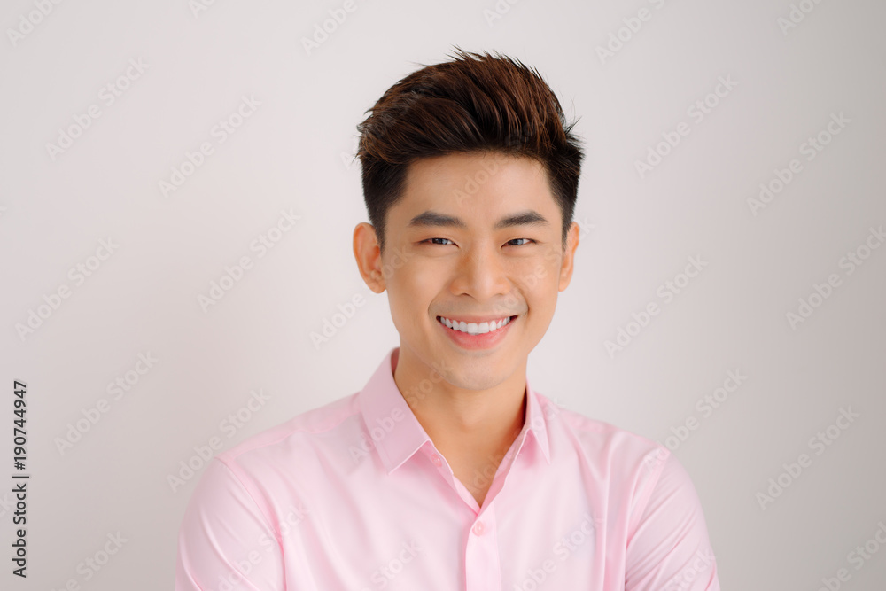 Handsome asian man stand and smile posing on gray background