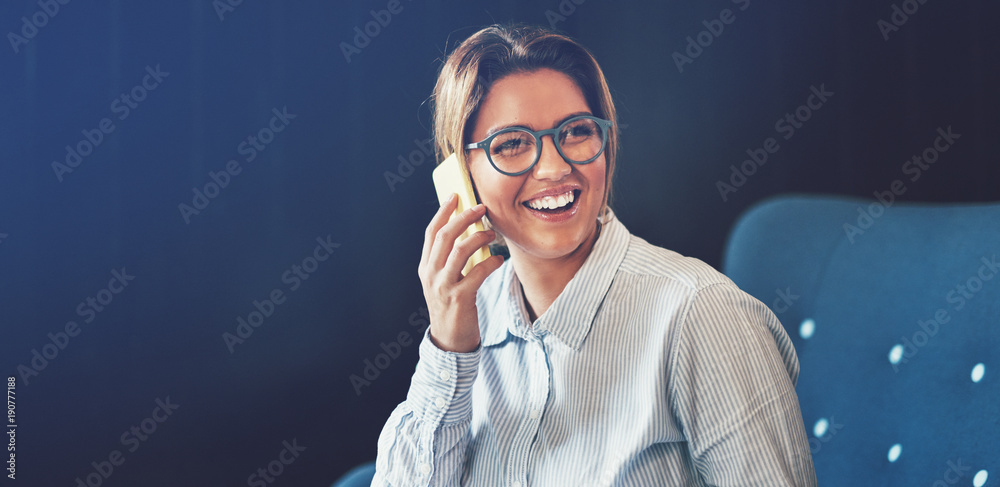 Young businesswoman laughing while talking on her cellphone