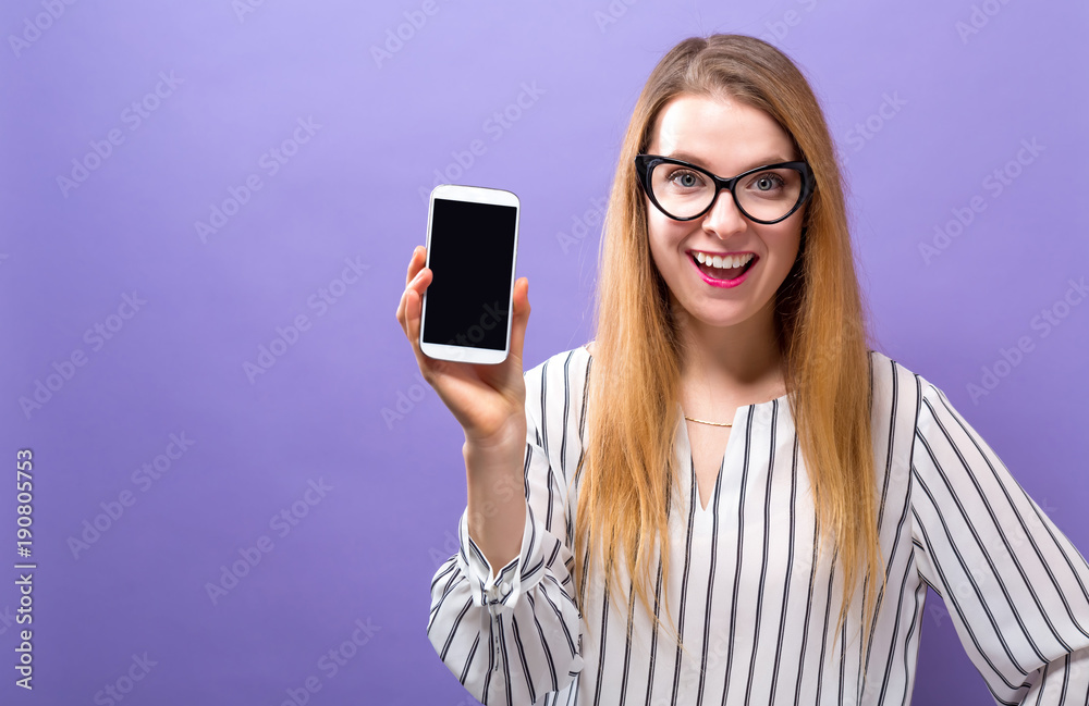 Young woman holding out a cellphone in her hand