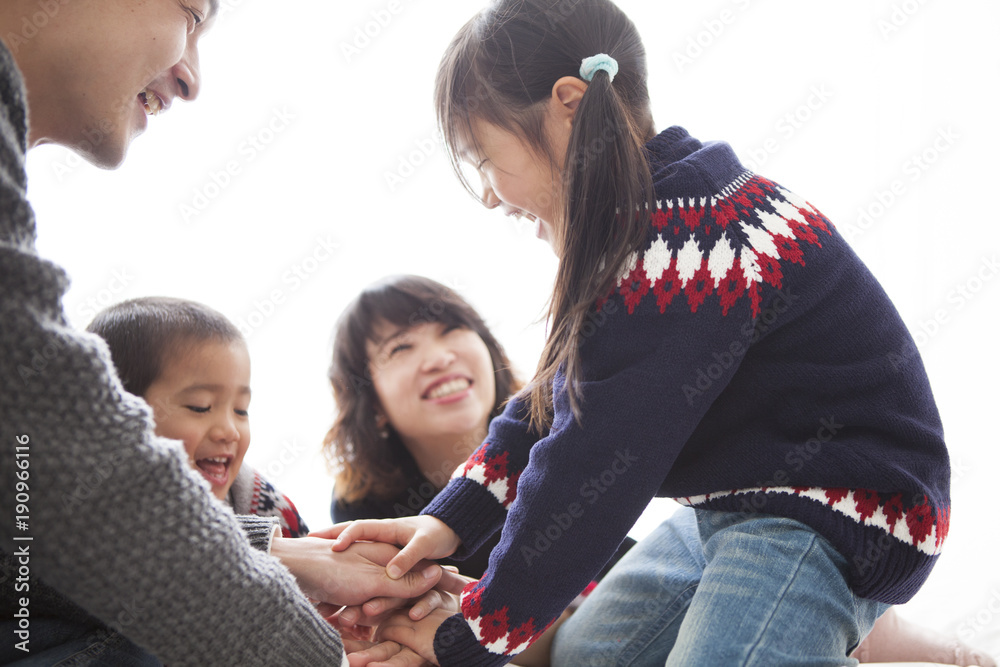 お父さん、お母さん、男の子、女の子の四人家族。楽しそうに遊んでいるところ。