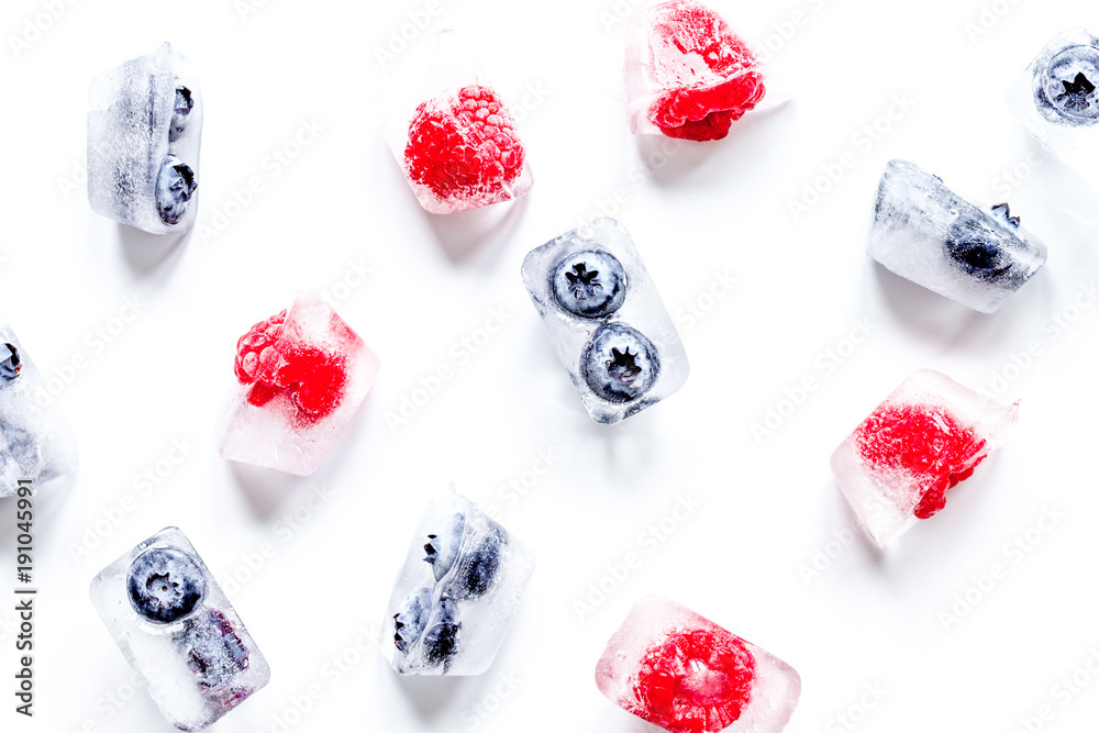 ice cubes with fresh berries on white background top view