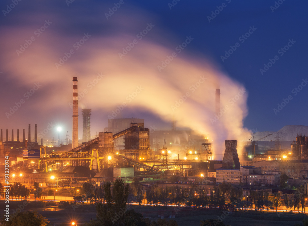 Metallurgical plant at night. Steel factory with smokestacks. Steelworks, iron works. Heavy industry