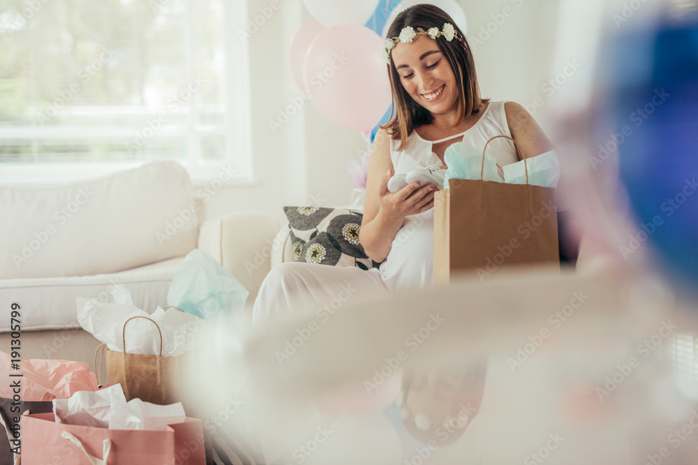 Expecting mother opening gifts received at baby shower