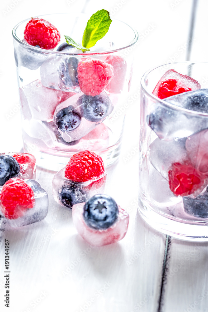 Frozen berries in glass for cocktail on wooden table background