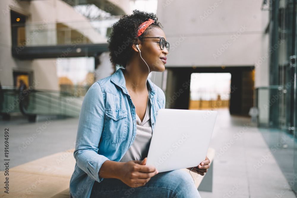 Young student deep in thought while working on a laptop