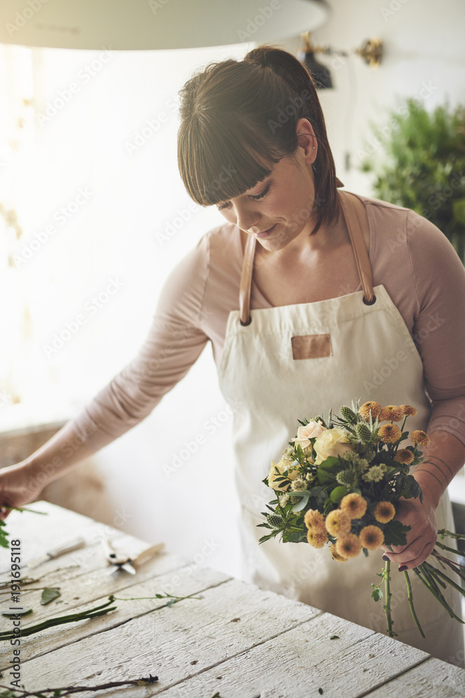 女花匠站在她的花店里做花束