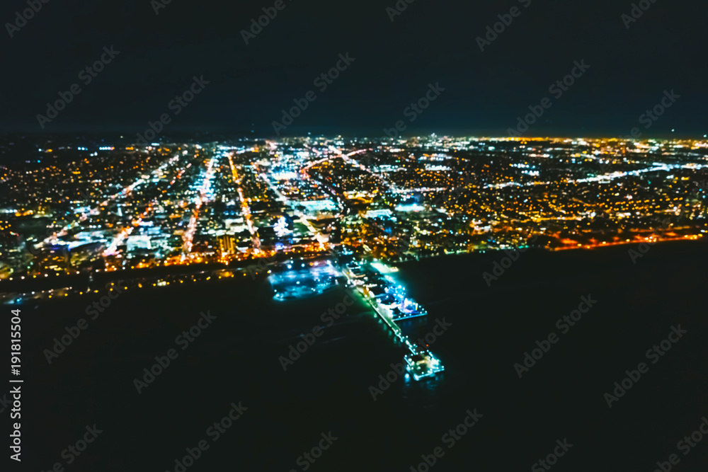 Aerial defocused view of the Santa Monica shoreline, amusment park and pier at night