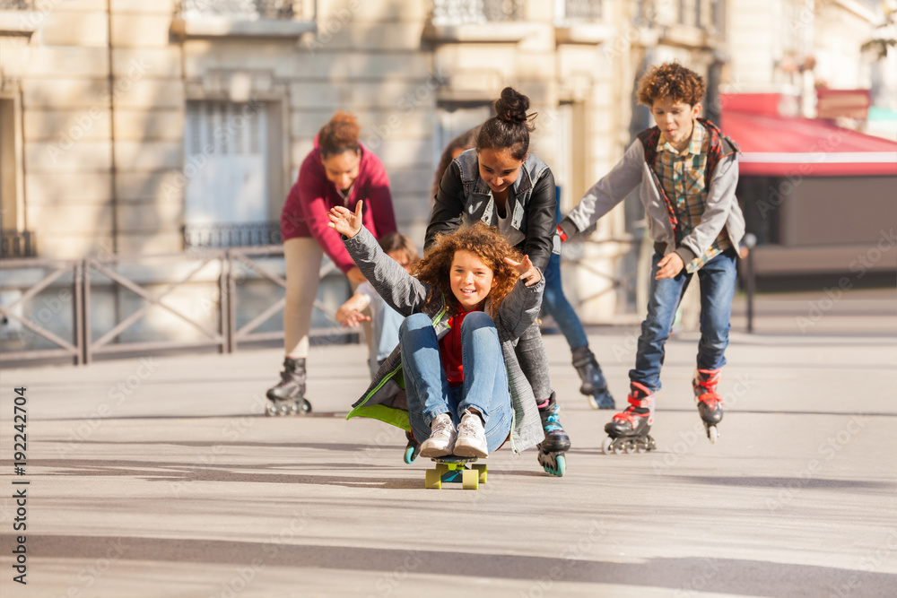 Happy teens rollerblading and skateboarding