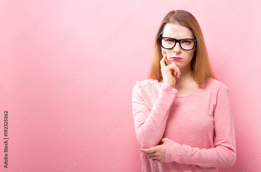 Young woman in a thoughtful pose on a solid background