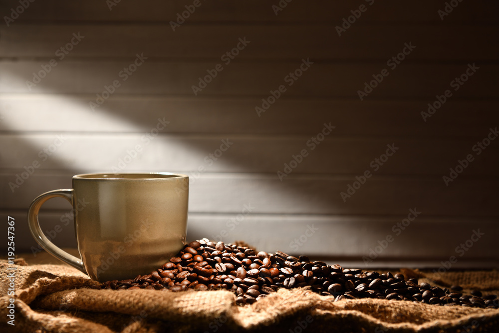 Coffee cup and coffee beans on old wooden background