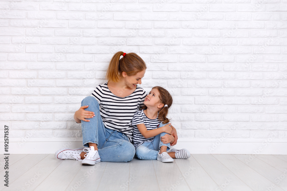 happy family mother and child daughter near an empty wall