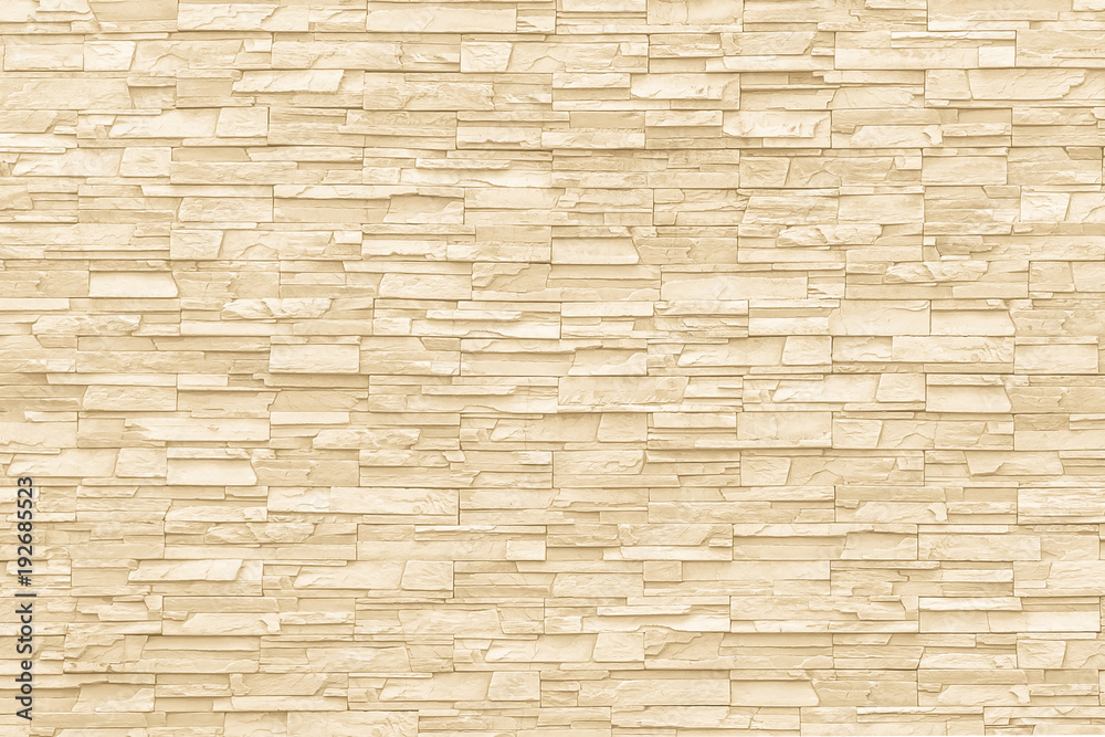 Rock stone brick tile wall aged texture detailed pattern background in cream beige brown color