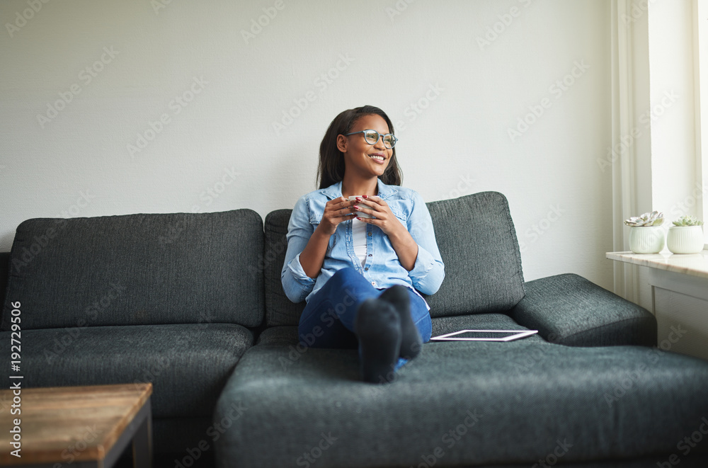 Young African woman relaxing at home with a digital tablet