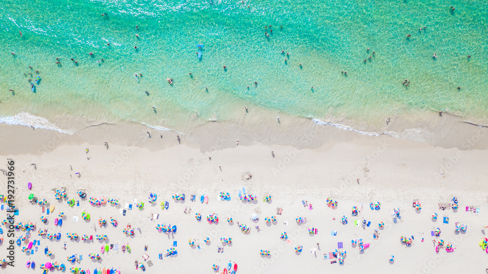 Aerial view Tropical white sand beach with azure clear water, umbrella and lush greenery. Top view. 