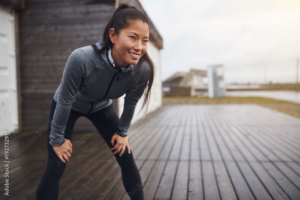 微笑的亚洲女人在慢跑时屏住呼吸