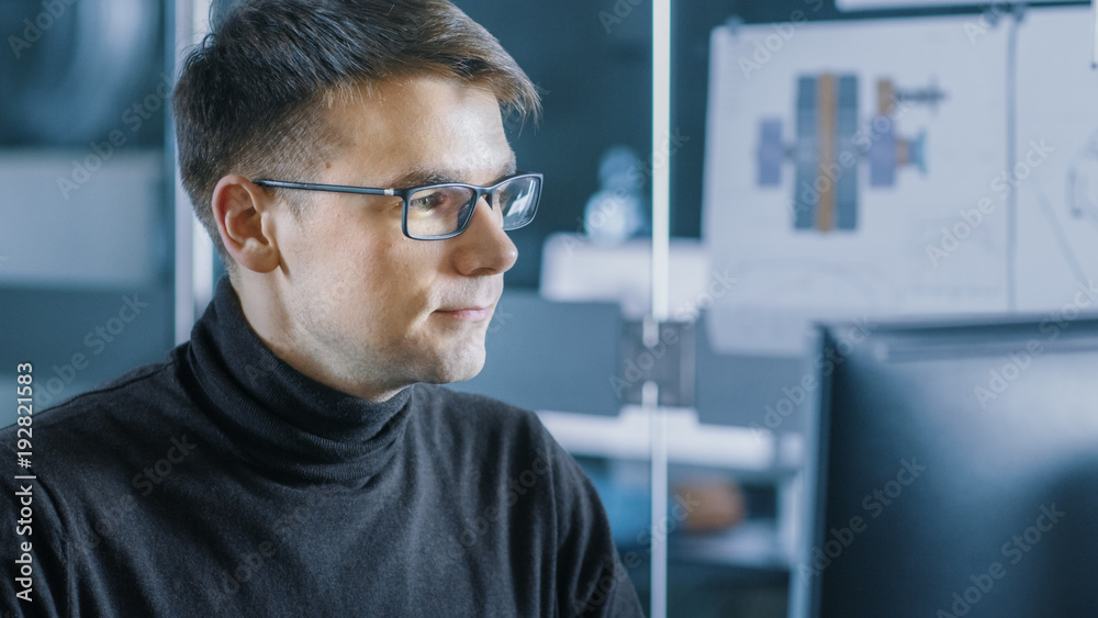 Young Male Industrial Engineer Works on a Personal Computer. Handsome Smart Man in the Bright Modern