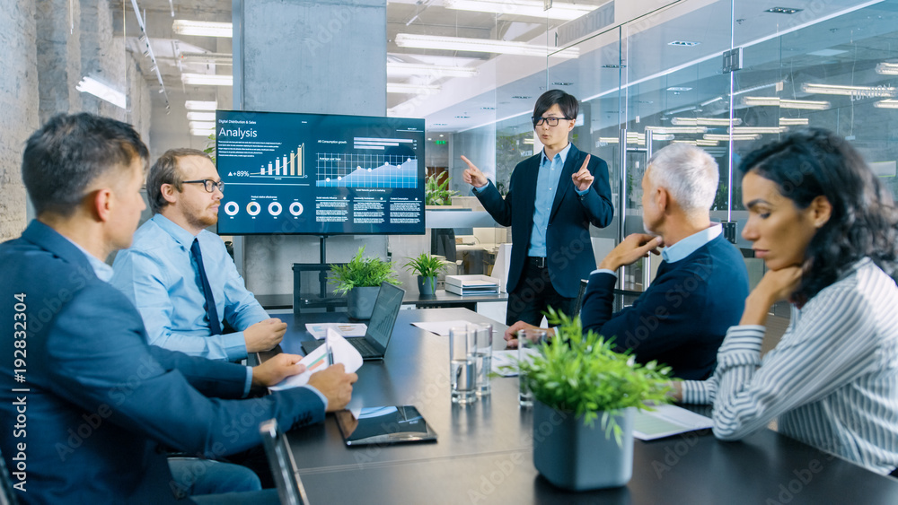 Asian Businessman Gives Report/ Presentation to His Business Colleagues, Pointing at the Results Sho