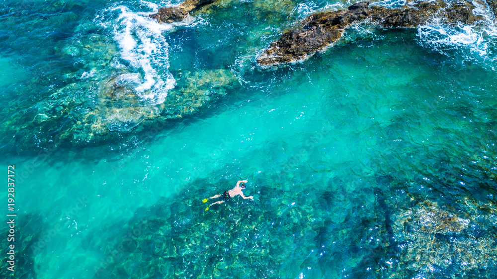 Aerial view Young man snorkeling in a clear tropical sea, Phuket, Thailand