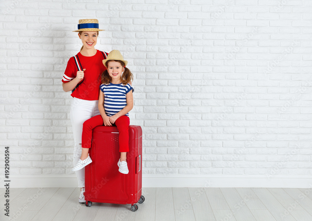 concept travel and tourism. mother and child daughter with suitcase near wall