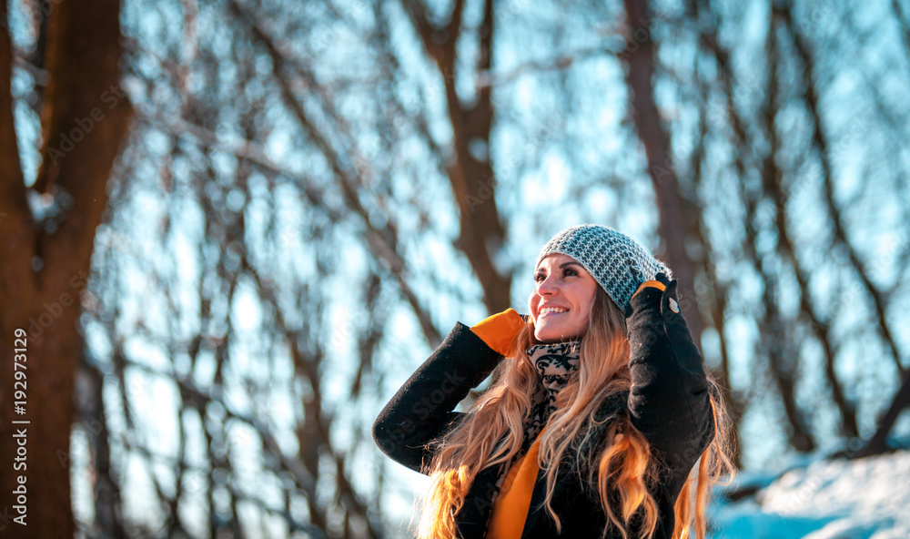 Portrait of smiling woman in the winter park at sunny day