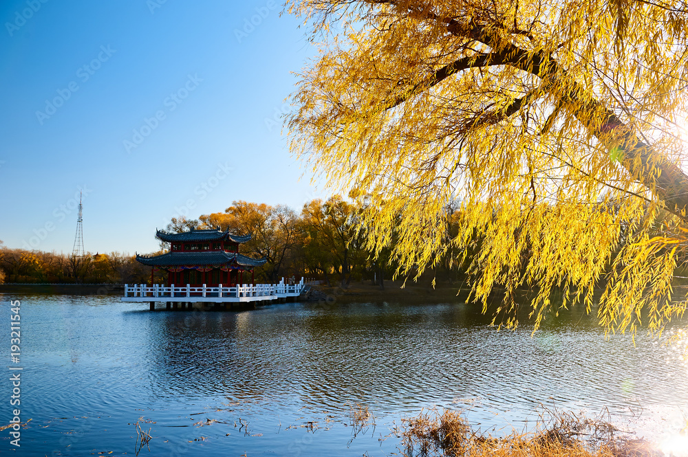 The fall trees and ancient buildings lakeside.