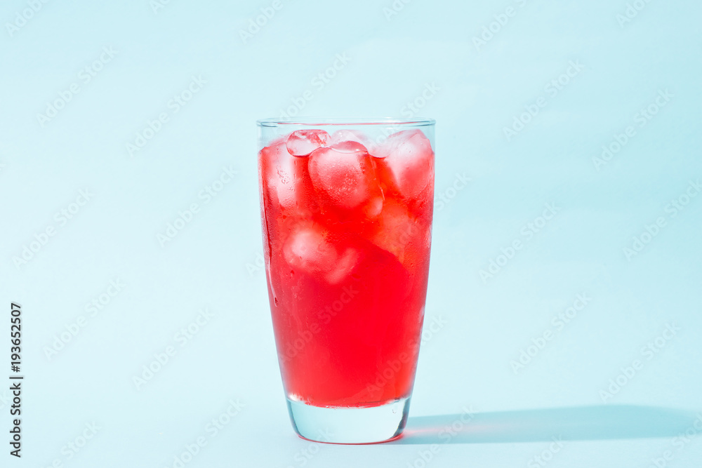 Soda. Red sparkling water with ice in a glass