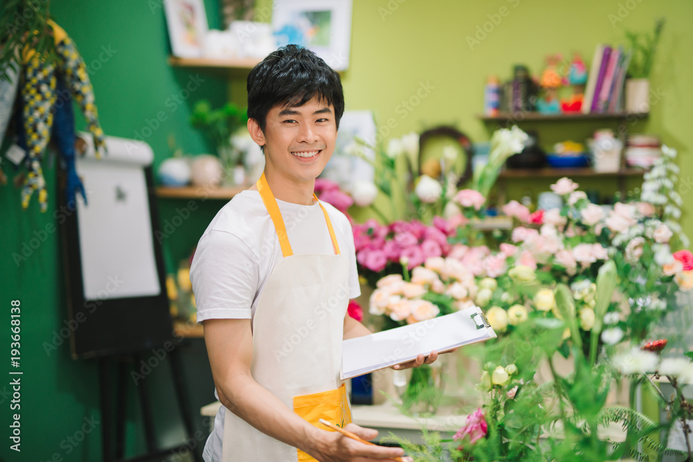 微笑的花店老板工作的肖像。小企业。