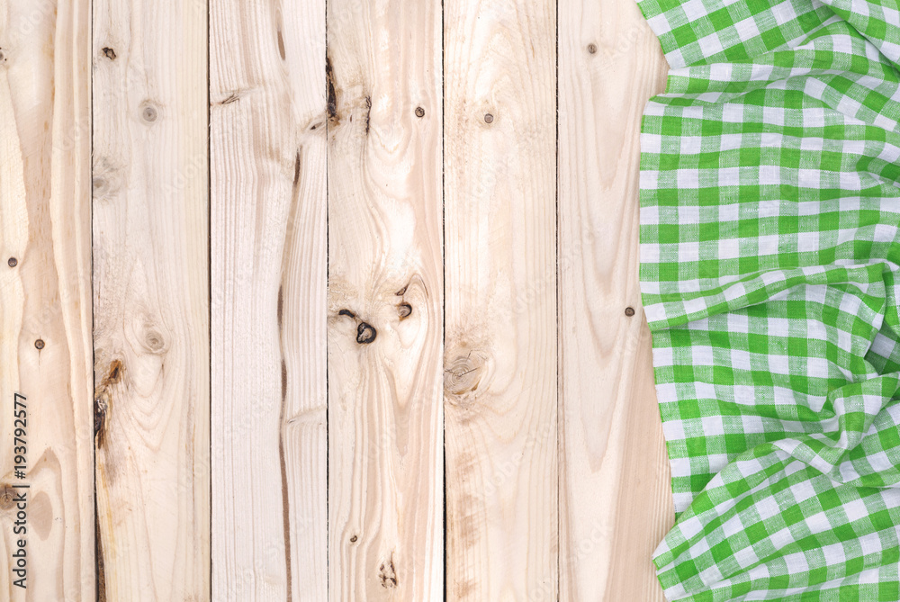 Green napkin cloth on wooden table, top view