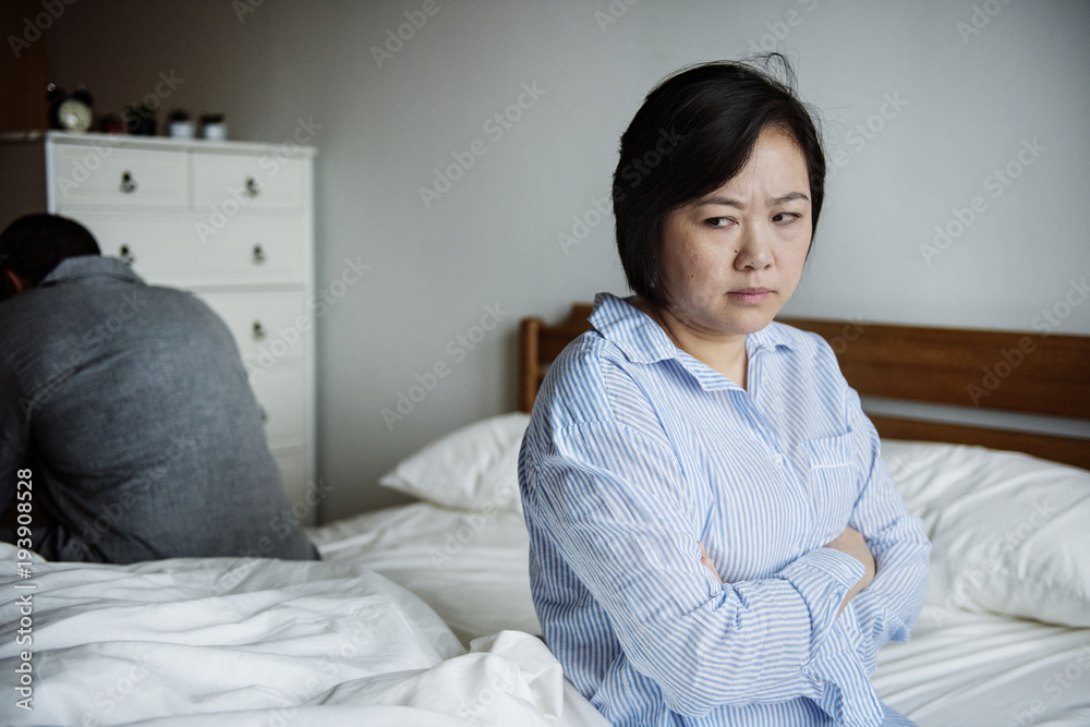 An upset woman in a bed room