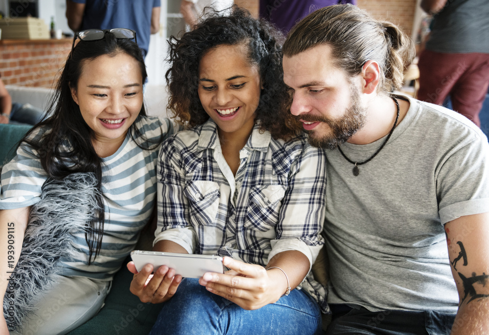 Group of diverse friends playing game on mobile phone