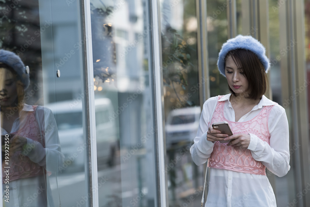 スマートフォンを使いお店を探している綺麗な女性。