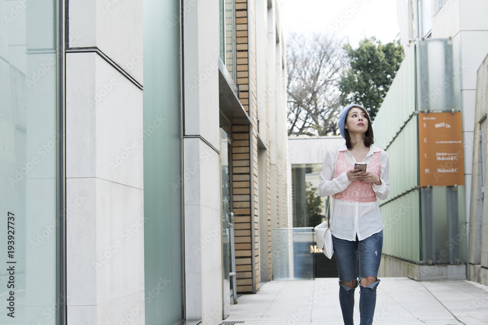 スマートフォンで道を探している女子大学生。