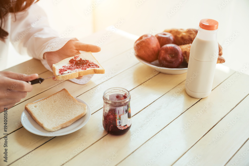 Asian girl who just wake up in the morning as relaxed. She was put down the jam on bread.