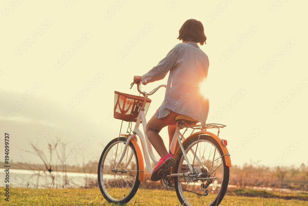 日落时分，一名年轻的亚洲女子在公园骑自行车