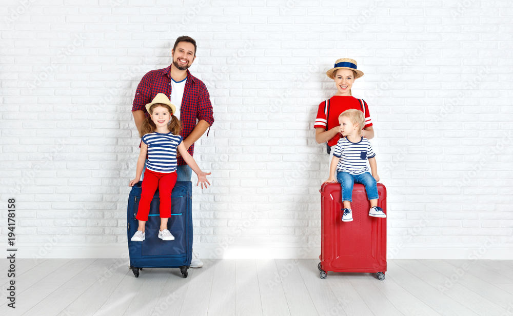 concept travel and tourism. happy family with suitcases near   wall