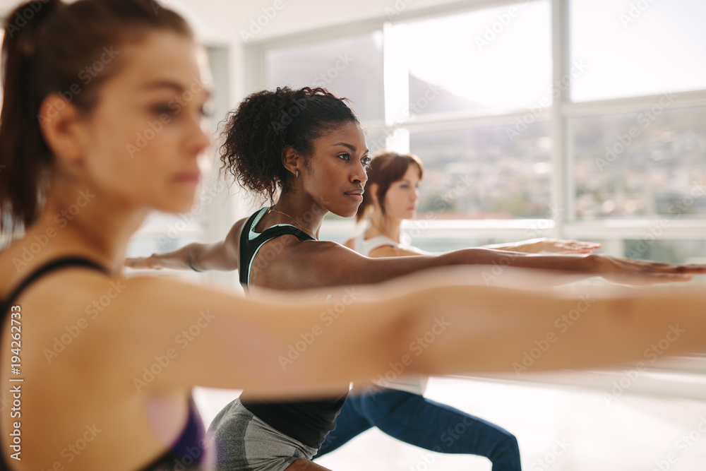 Woman doing the warrior pose during yoga class.