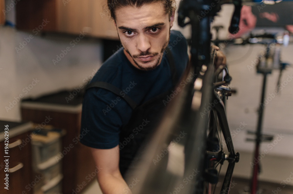 Mechanic repairing a bicycle in workshop