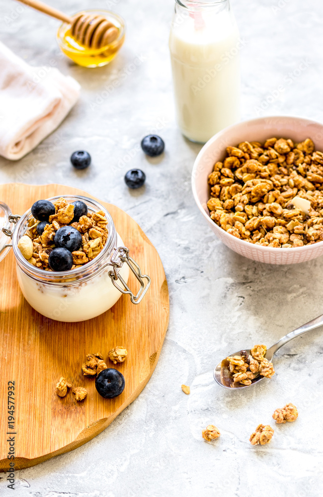 Morning granola with yogurt, honey and berries on white table