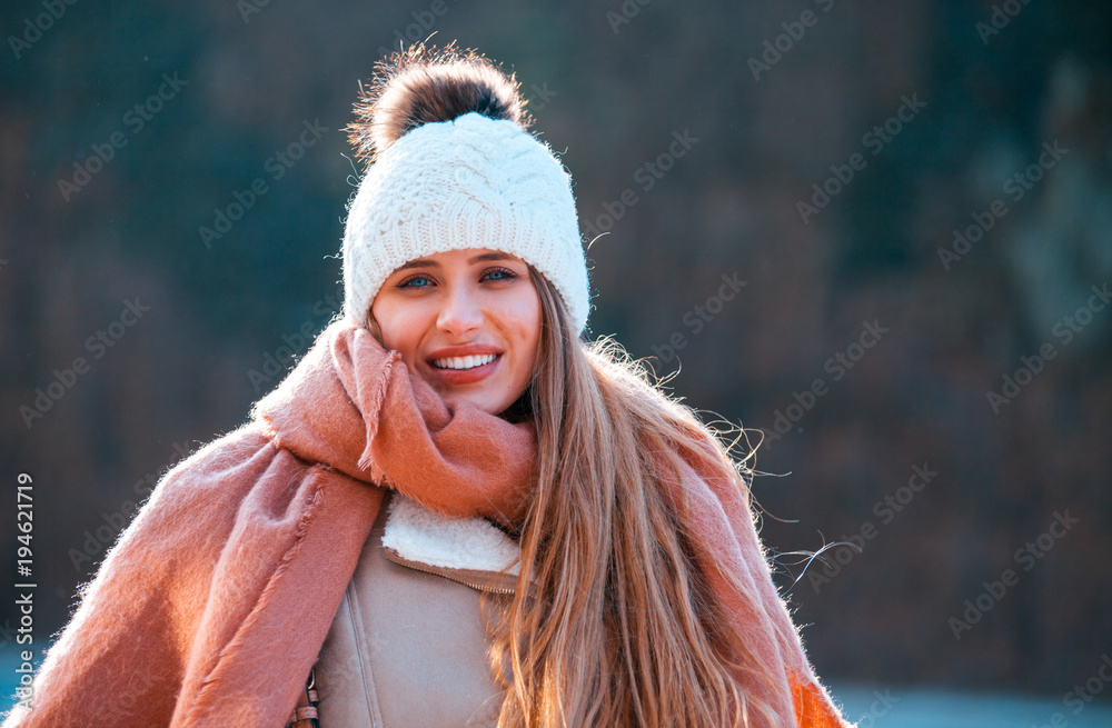 寒冷的冬日，戴着针织毛线帽和大围巾的微笑女人