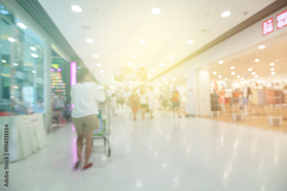 Blurred defocused background of generic supermarket people walking shopping.