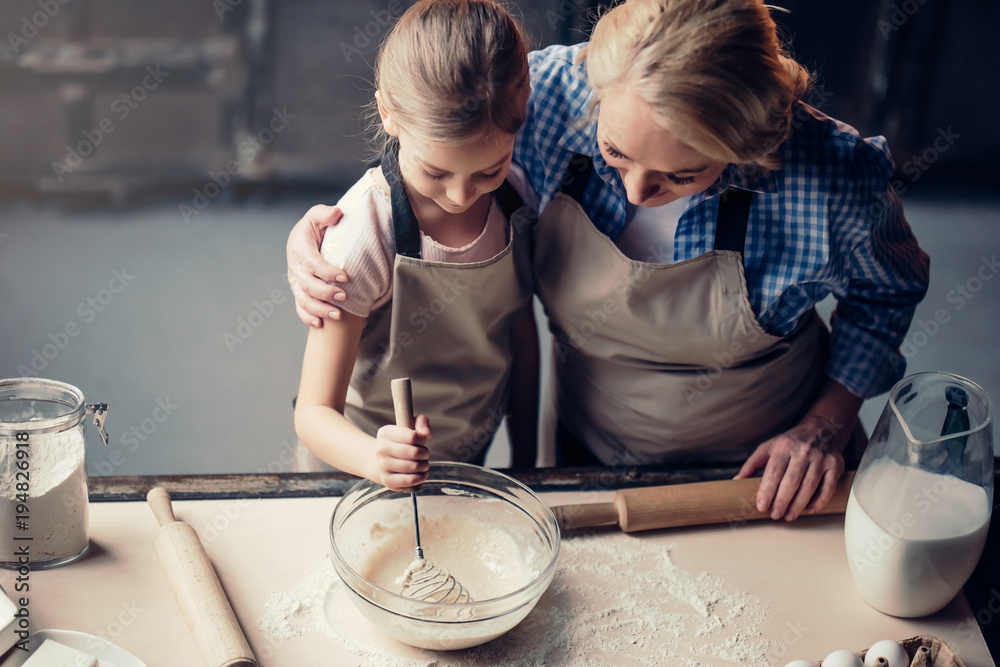 Grandmother and granddaughter cooking on kitchen