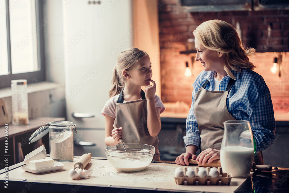 Grandmother and granddaughter cooking on kitchen