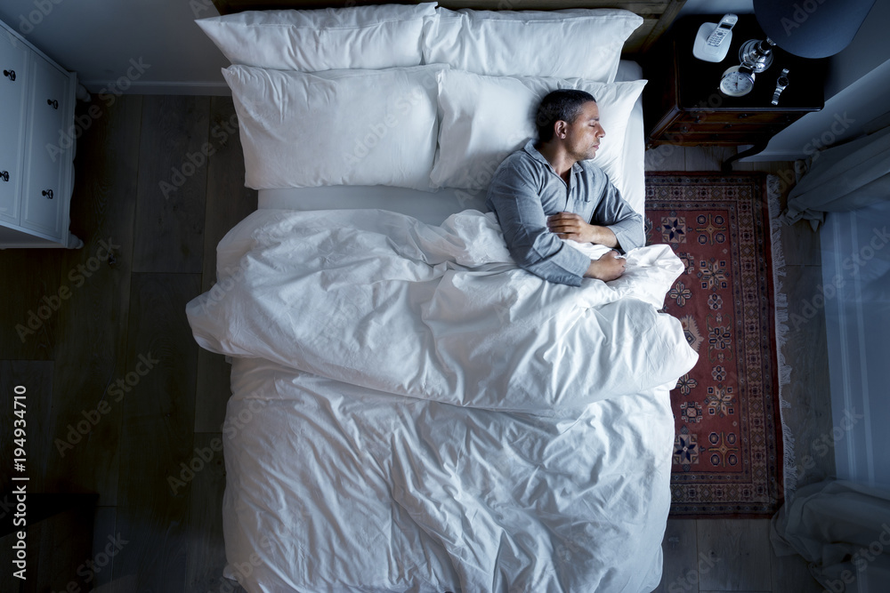 French man sleeping alone on bed