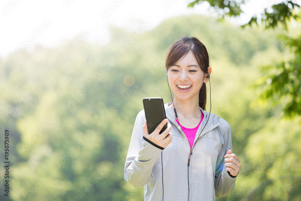 公園でジョギングするスポーティーな女性