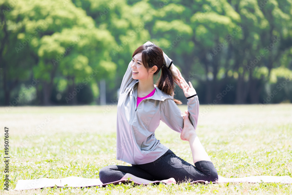 公園でヨガをするスポーティーな女性