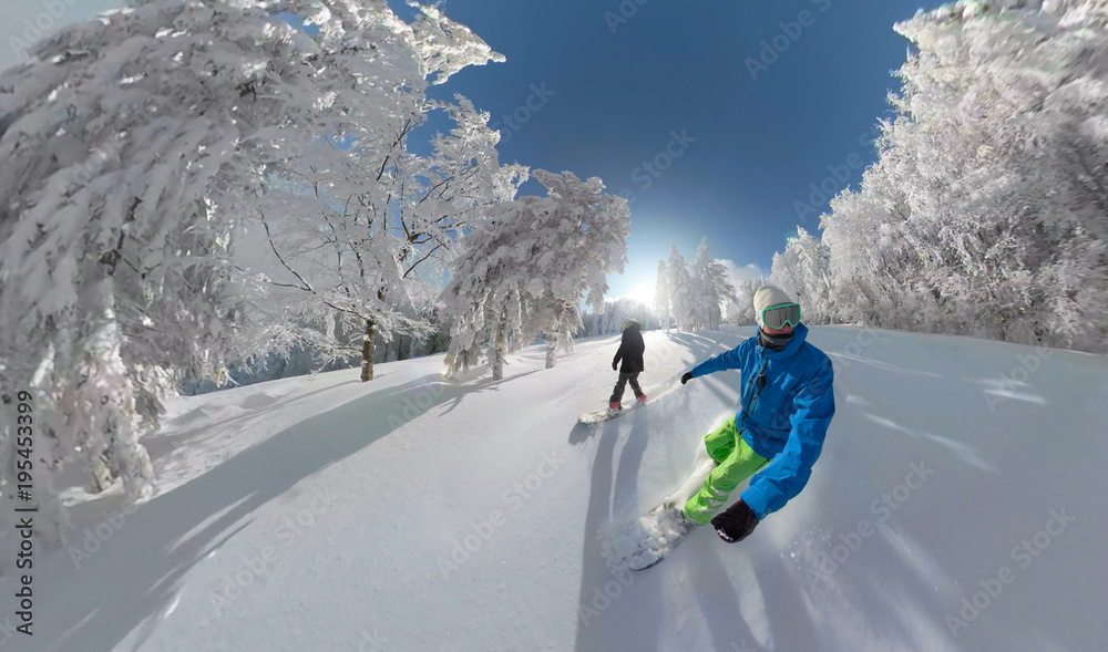 LENS FLARE Young snowboard couple riding fresh powder snow in winter wonderland