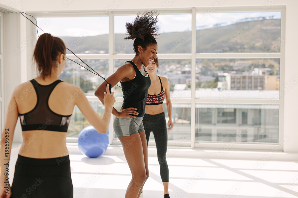 Woman jumping rope with friends in gym