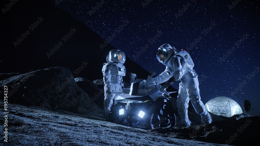 Two Astronauts in Space Suits on an Alien Planet Prepare Space Rover for Surface Exploration Mission