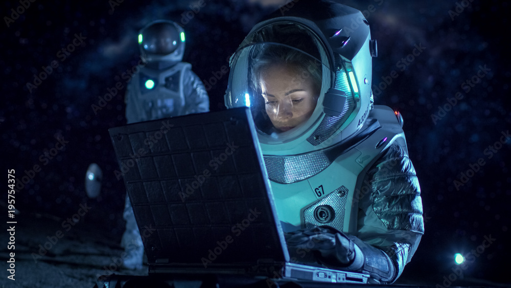 Female Astronaut Wearing Space Suit Works on a Laptop, Exploring Newly Discovered Planet, Communicat